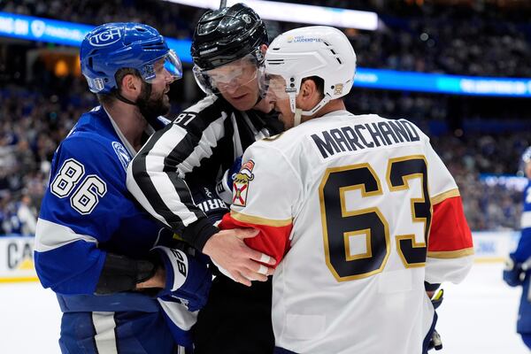 Linesman Devin Berg (87) separates Tampa Bay Lightning right wing Nikita Kucherov (86) and Florida Panthers center Brad Marchand (63) during the second period in Game 2 of an NHL hockey Stanley Cup first-round playoff series, Thursday, April 24, 2025, in Tampa, Fla. (AP Photo/Chris O'Meara)