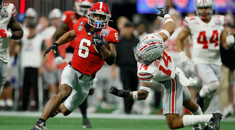 Georgia running back Kenny McIntosh gets by Ohio State safety Ronnie Hickman for a 52-yard run during the second quarter in the Peach Bowl. Georgia won 42-41. (Jason Getz / Jason.Getz@ajc.com)