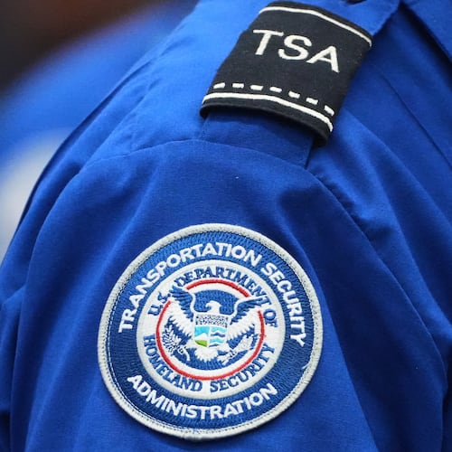 A TSA agent wears a Transportation Security Administration badge while checking identification at Seattle-Tacoma International Airport, Thursday, Nov. 6, 2025, in SeaTac, Wash. (AP Photo/Lindsey Wasson)