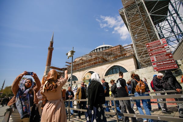 People wait in line to visit Byzantine-era Hagia Sophia mosque next to scaffolds installed for restoration works, in Istanbul, Turkey, Sunday, April 13, 2025. (AP Photo/Emrah Gurel)
