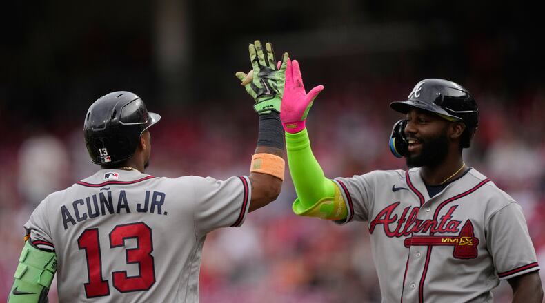 Atlanta Braves' Ronald Acuña Jr. left, celebrates after hitting a solo home run with Michael Harris II, right, during the first inning of a baseball game against the Cincinnati Reds in Cincinnati, Friday, May 29, 2026. (AP Photo/Carolyn Kaster)