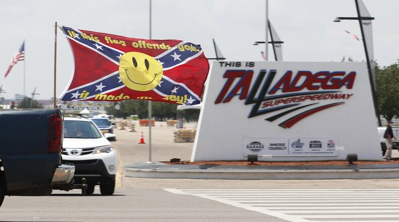 Race fans fly Confederate battle flags and United States flags as they drive by the entrance to Talladega Superspeedway prior to a NASCAR Cup Series auto race in Talladega Ala., Sunday, June 21, 2020.. (AP Photo/John Bazemore)