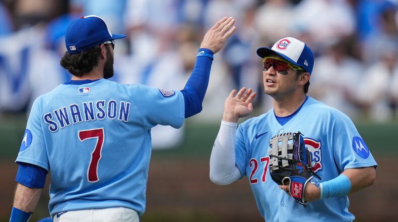 Chicago Cubs' Dansby Swanson (7) and Seiya Suzuki (27) celebrate their team's win over the New York Mets in a baseball game Friday, April 17, 2026, in Chicago. (AP Photo/Erin Hooley)