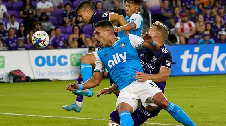Charlotte FC's Daniel Rios, front, becomes entangled with Orlando City's Robin Jansson, right, while trying to take a shot on goal during the first half of an MLS soccer match, Saturday, April 30, 2022, in Orlando, Fla. (AP Photo/John Raoux)