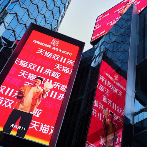 Window cleaners labor an commercial office as an advertisement billboard promoting Tmall's Singles' Day sale at a shopping district in Beijing on Nov. 10, 2025. (AP Photo/Andy Wong)