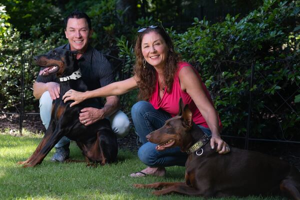 Matt and Laurel Nelson with their dogs Legend and Lilac in the backyard of their home in the gated Ellard community in Roswell on Wednesday, May 13, 2026. (Ben Gray for the AJC)