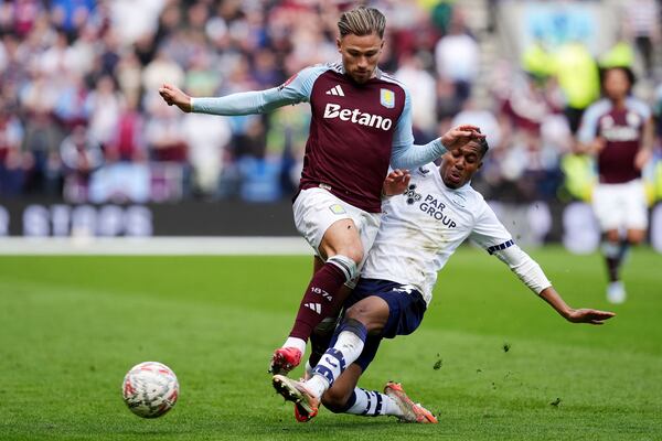 Aston Villa's Matty Cash, left, is tackled by Preston North End's Jayden Meghoma during the English FA Cup quarter final soccer match at Deepdale, Preston, England, Sunday, March 30, 2025. (Martin Rickett/PA via AP)