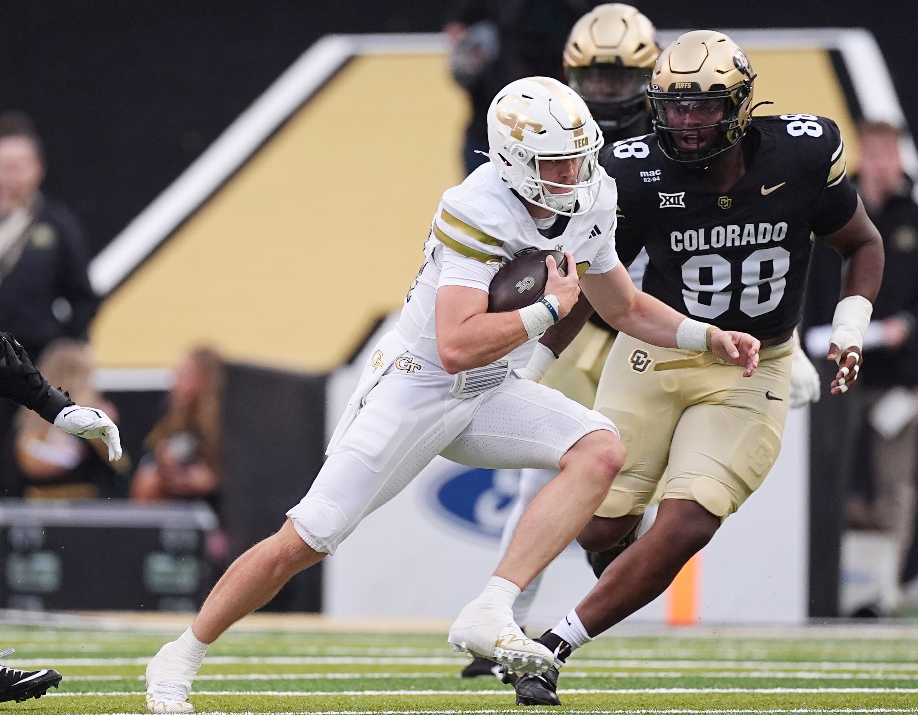 Georgia Tech quarterback Haynes King, left, runs for a short gain as Colorado defensive tackle Amari McNeill (88) pursues him in the first half of an NCAA college football game Friday, Aug. 29, 2025, in Boulder, Colo. (AP Photo/David Zalubowski)