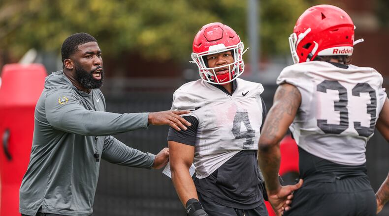 An injured Nolan Smith (4), who is out for the season, has been coaching Robert Beal (33) and UGA's other outside linebackers in practice. (Photo by Mackenzie Miles/UGA Athletics)