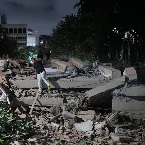 A man jumps on a collapsed building after an earthquake in Caracas, Venezuela, Wednesday, June 24, 2026. (AP Photo/Adrian Naranjo)