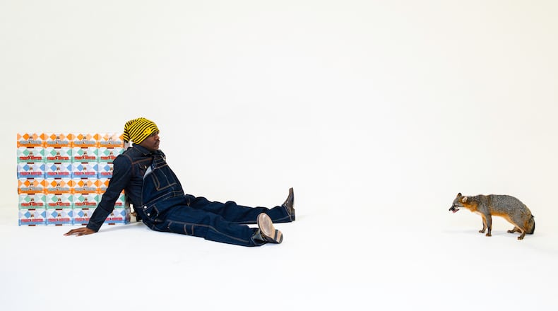 Rapper Lil Yachty poses with six-packs of Yacht Water, the Atlanta-based tequila seltzer he co-owns with Kevin "Coach K" Lee of Quality Control Music and Sneaky Spirits.