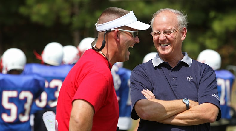 Outgoing Berkmar football coach John Thompson (left) and former WSB-TV sports anchor Bill Hartman (right) have a laugh during a Patriots practice in 2008. AJC file photo