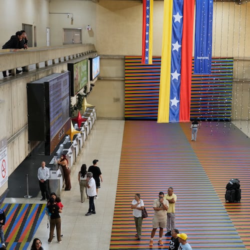 Travelers wait in the main hall of the Simon Bolivar Maiquetia International Airport in Maiquetia, Venezuela, Sunday, Nov. 23, 2025, after several international airlines canceled flights following a warning from the U.S. Federal Aviation Administration about a hazardous situation in Venezuelan airspace. (AP Photo/Ariana Cubillos)