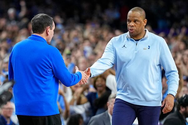 North Carolina head coach Hubert Davis, right, shakes hands with Duke head coach Mike Krzyzewski after North Carolina's win in a college basketball game during the semifinal round of the Men's Final Four NCAA tournament, Saturday, April 2, 2022, in New Orleans. (AP Photo/David J. Phillip)