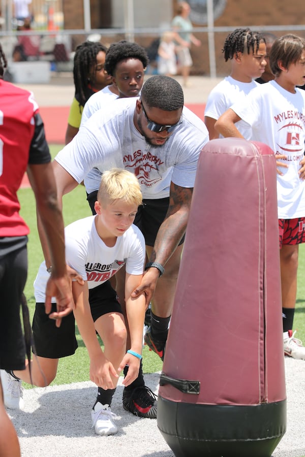 Myles Murphy, a former AJC Super 11 player while at Hillgrove and now an NFL player with the Cincinnati Bengals, gives tips to a camper. (Warren J. Buchanan Sr./Hillgrove)