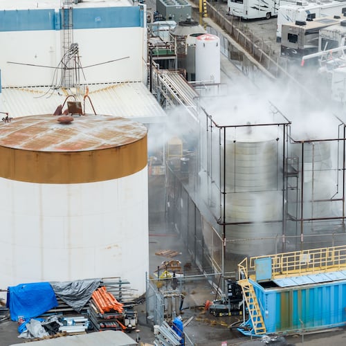 Water is sprayed on a damaged tank at GKN Aerospace in Garden Grove, Calif., on Sunday, May 24, 2026, after the tank containing a chemical used to make plastic parts overheated Thursday. (AP Photo/Ethan Swope)