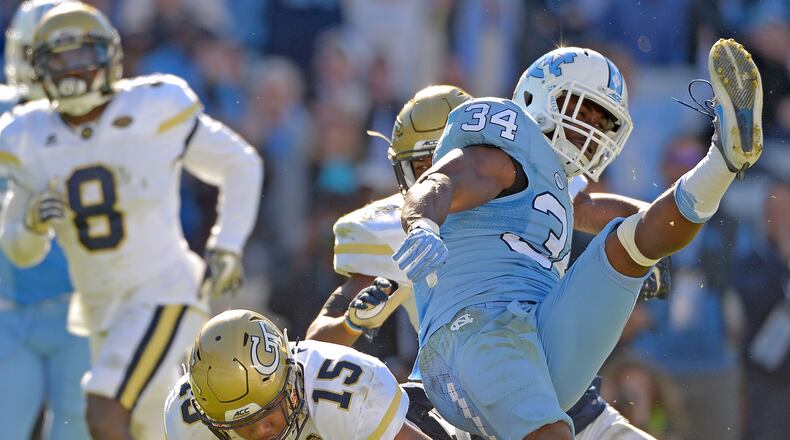 A.J. Gray #15 and Corey Griffin #14 of the Georgia Tech Yellow Jackets tackle Elijah Hood #34 of the North Carolina Tar Heels during the game at Kenan Stadium on November 5, 2016 in Chapel Hill, North Carolina. North Carolina won 48-20. (Photo by Grant Halverson/Getty Images)