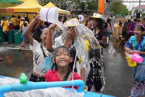 People take part in the first day of annual water festival also known as "Thingyan," in Naypyitaw, Myanmar, Sunday, April 13, 2025. (AP Photo/Aung Shine Oo)