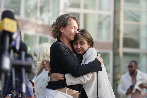 Anamaria Baralt, left, cousin of Erik and Lyle Menendez, left, gets a hug as she leaves the courthouse after the brothers' resentencing hearing Tuesday, May 13, 2025, in Los Angeles. (AP Photo/Damian Dovarganes)
