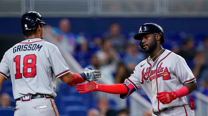 Atlanta Braves' Vaughn Grissom (18) congratulates Michael Harris II after Harris scored on a sacrifice fly by Dansby Swanson during the sixth inning of a baseball game against the Miami Marlins, Friday, Aug. 12, 2022, in Miami. (AP Photo/Wilfredo Lee)
