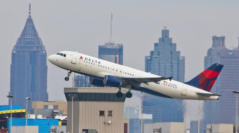 With gray skies over the Atlanta skyline a Delta jet takes off on Tuesday, Oct. 30, 2012. JOHN SPINK / JSPINK@AJC.COM