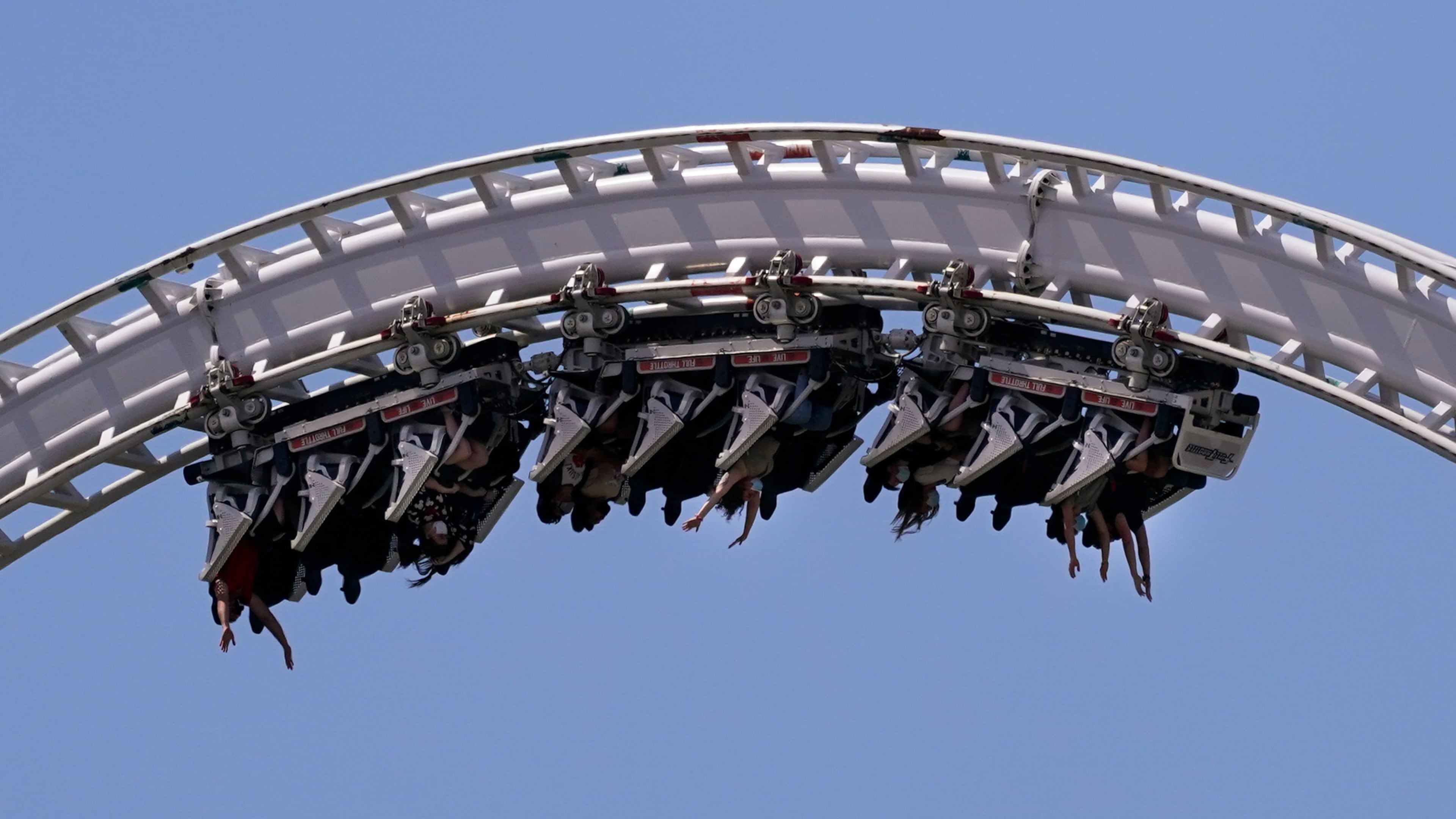 FILE - Visitors ride a roller coaster at Six Flags Magic Mountain in Valencia, Calif., April 1, 2021. (AP Photo/Jae C. Hong, File)