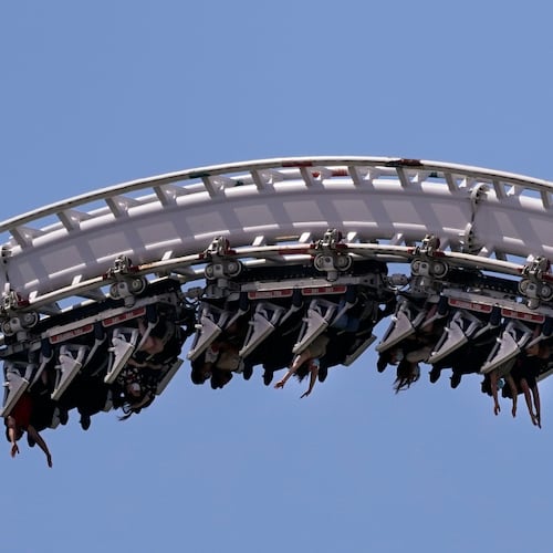 FILE - Visitors ride a roller coaster at Six Flags Magic Mountain in Valencia, Calif., April 1, 2021. (AP Photo/Jae C. Hong, File)