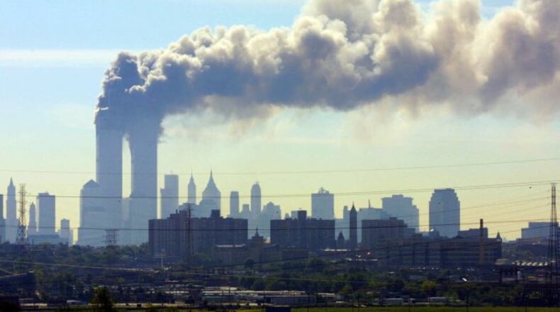 As seen from the New Jersey Turnpike near Kearny, N.J., smoke billows from the twin towers of the World Trade Center in New York after airplanes crashed into both towers Tuesday, Sept.11, 2001. (AP Photo/Gene Boyars)