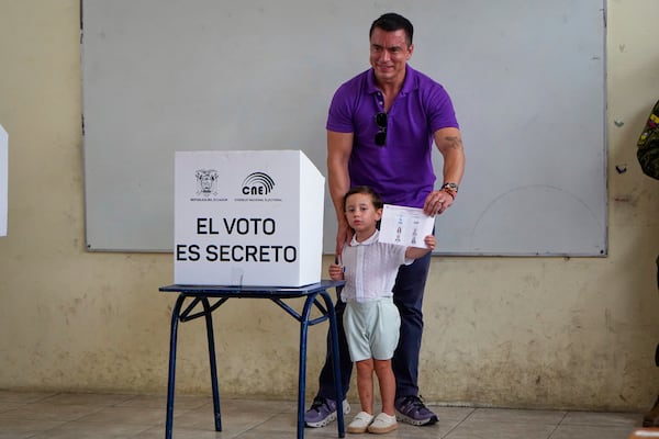 Incumbent President Daniel Noboa shows his ballot casts before voting, accompanied by his children, in the presidential election runoff in Olon, Ecuador, Sunday, April 13, 2025. (AP Photo)