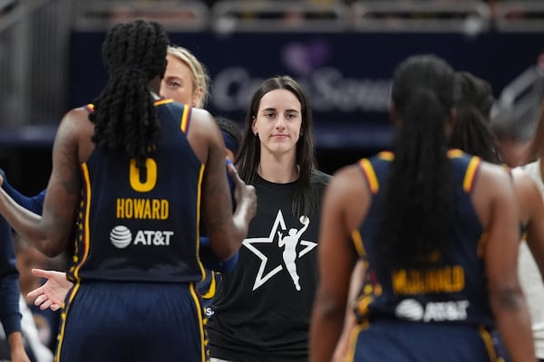Indiana Fever's Caitlin Clark, middle greets teammates during the first half of a WNBA basketball game against the Las Vegas Aces, Thursday, July 3, 2025, in Indianapolis. (AP Photo/Michael Conroy)