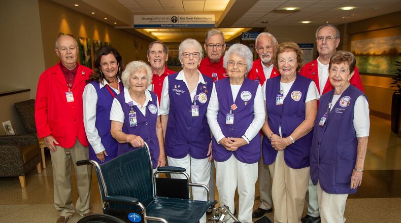 volunteers Ken Wilger (from left), Vicky Hagan, David Kilroy, Irene Scott, Lee Gibbons, Albert Schaef, Mary Sproat, JC Palmer, Ruth Plasket, Joe Ed Smith & Martha Bright, are all age 80 and older. They push wheelchairs at WellStar Kennestone Hospital in Marietta. Photo by Phil Skinner