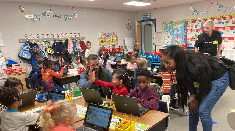 Patrick Elementary first graders get coding help from Accenture employees (l-to-r) Sean Kelstrom, Olamipo Solebo, and Theresa Cash.