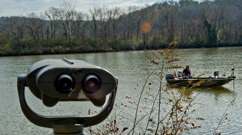 A pair of binoculars rise from the River Boardwalk Trail at the Chattahoochee Nature Center as Paul Jusiewicz fishes from his boat along the river in Roswell on Saturday, December 27, 2014. JONATHAN PHILLIPS / SPECIAL