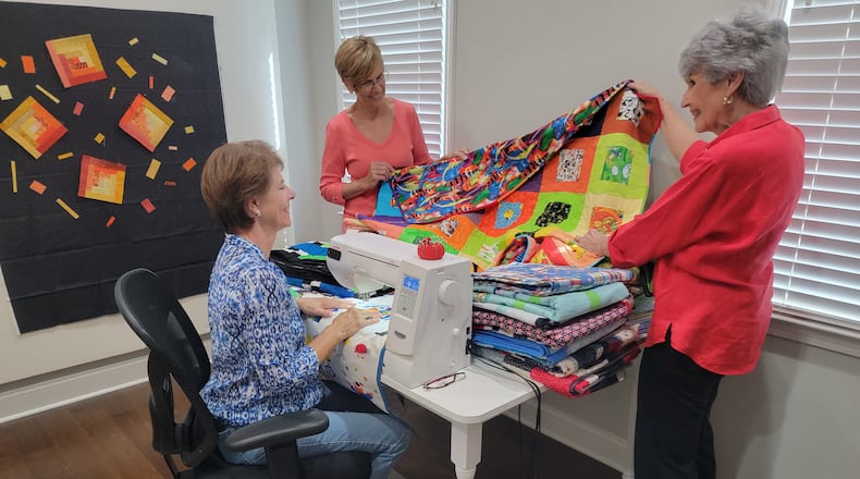 Members of the East Cobb Quilters' Guild produce quilts, placements and pillowcases for a variety of nonprofits. Pictured left to right are members Meridith Mask, Judy Weathers and Linda Bailey .
