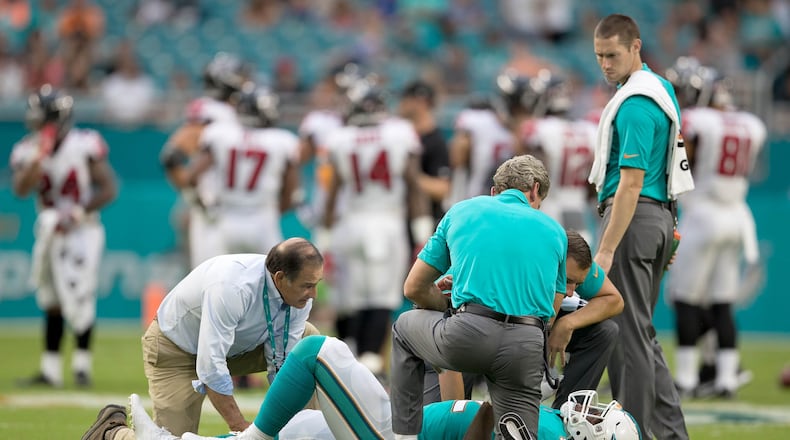 Miami Dolphins linebacker Raekwon McMillan (52) is attended to after being injured on the opening kickoff during pre-season game against Atlanta Falcons at Hard Rock Stadium in Miami Gardens, Florida on August 10, 2017. (Allen Eyestone / The Palm Beach Post)