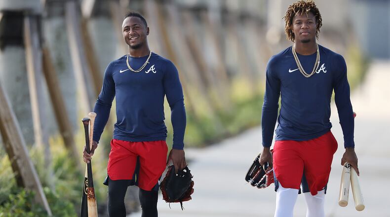 With bats and gloves in hand, Braves second baseman Ozzie Albies and outfielder Ronald Acuna head to the batting cages for some practice Thursday, Feb. 13, 2020, in North Port, Fla.