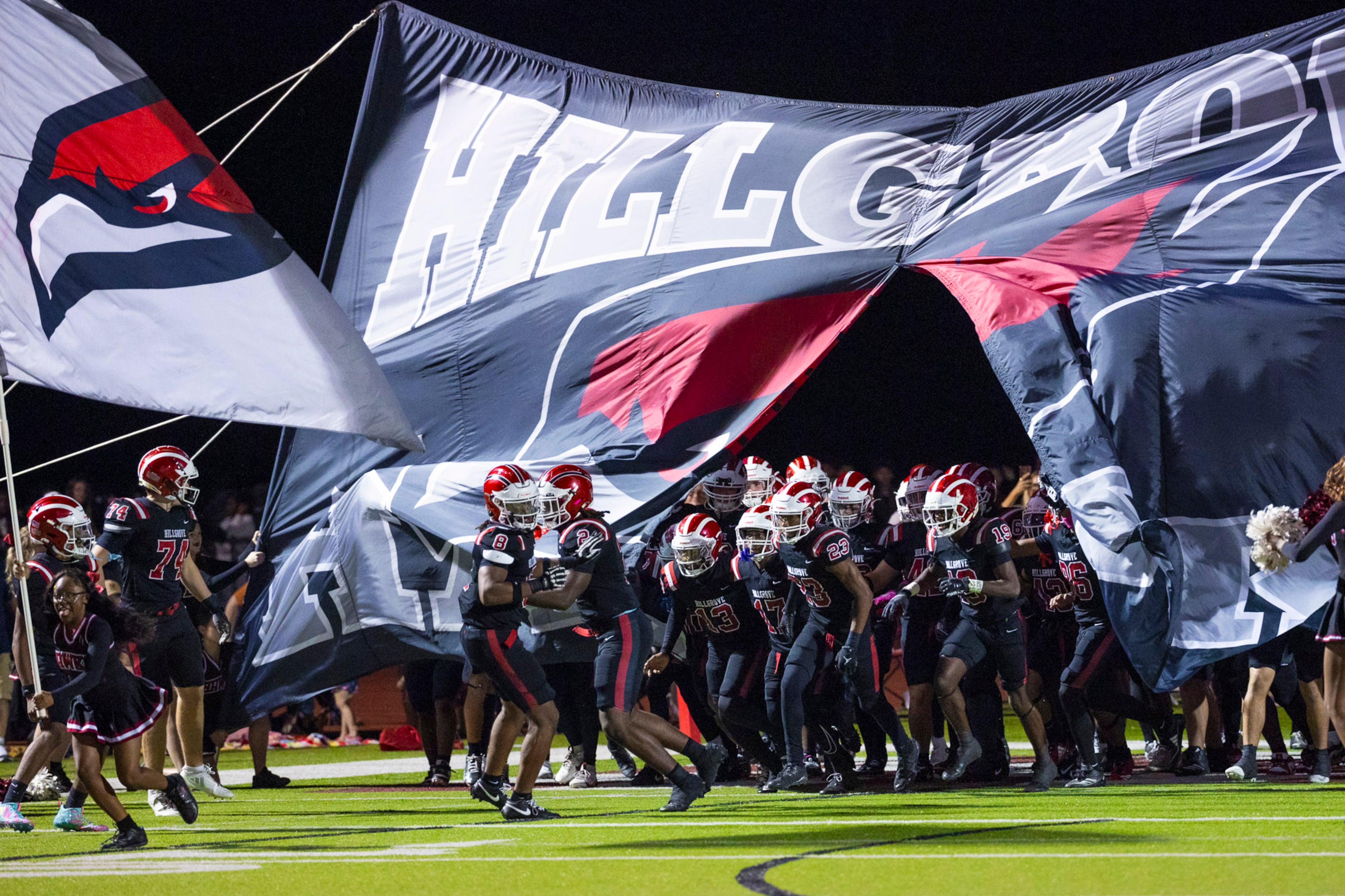 Hillgrove players run through the banner before the game against McEachern at Cobb Energy Hillgrove Stadium in Powder Springs, GA on Friday, October 17th, 2025. (Oscar Guevara Saenz for the AJC)