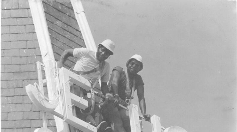 JESUS SAVES: William Henry Stanford (dark shirt) and his brother Jerry Stanford, install a new sign atop Big Bethel A.M.E. Church in 1979. More than 100 years earlier, their uncle helped build the church.