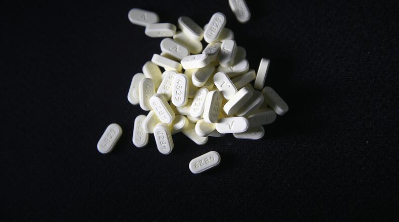Oxycodone pain pills prescribed for a patient with chronic pain lie on display on March 23, 2016 in Norwich, Connecticut. The Atlanta-based CDC estimates that most new heroin addicts first became hooked on prescription pain medication before graduating to heroin, which is stronger and cheaper.
