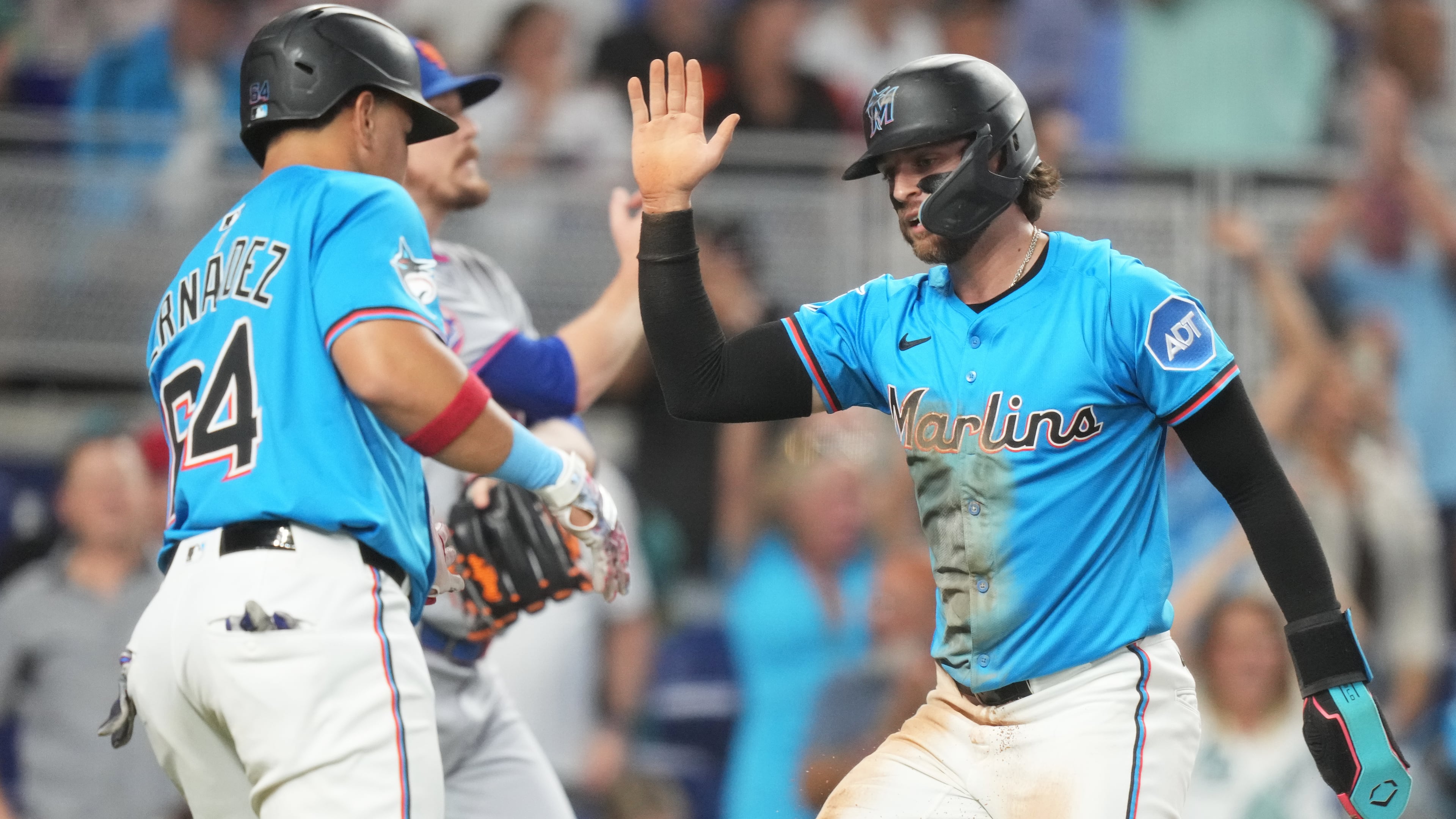 Miami Marlins' Connor Norby, right, is met by Heriberto Hernandez (64) after scoring on a double hit by Eric Wagaman during the fourth inning of a baseball game against the New York Mets1, Sunday, Sept. 28, 2025, in Miami. (AP Photo/Lynne Sladky)