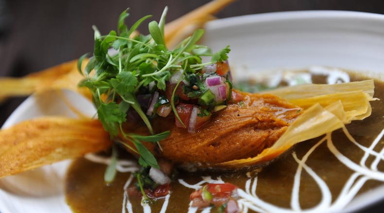 Pork Pibil Tamale with banana leaf-braised with bacon-corn masa, green chile sauce, crema and pico de gallo at Alma Cocina. (BECKY STEIN/special)