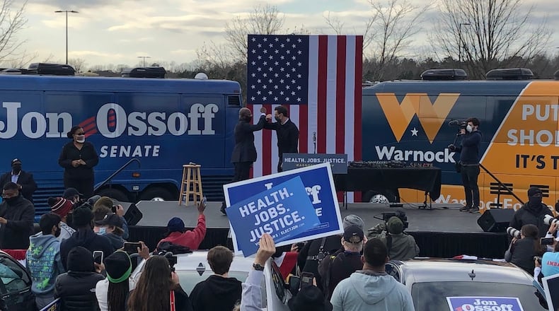 Rev. Raphael Warnock, left, greets fellow Democratic U.S. Senate candidate Jon Ossoff during a joint campaign event on Monday, Dec. 28, 2020, that was focused on motivating young voters in DeKalb County.