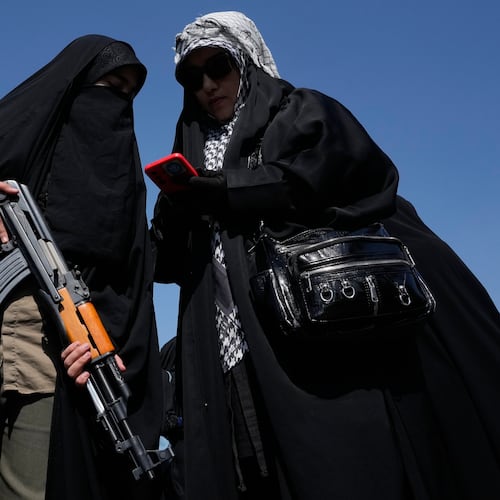 A woman member of the Basij paramilitary, affiliated with Iran's Revolutionary Guard, holds her gun during a state-organized rally in support of the supreme leader marking National Girl's Day in Tehran, Iran, Friday, April 17, 2026. (AP Photo/Vahid Salemi)