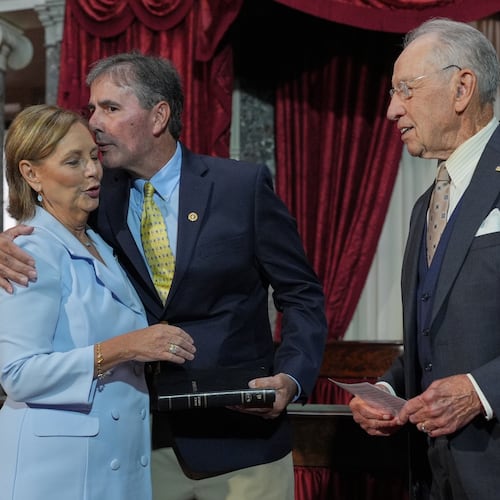 Sen. Darline Graham, R-S.C., sister of Sen. Lindsey Graham, R-S.C., is ceremonially sworn-in by President Pro Tempore of the Senate, Chuck Grassley, R-Iowa, in the Old Senate Chamber at the Capitol in Washington, Tuesday, July 14, 2026, as her husband Larry Nordone holds the Bible and gives her a kiss. (AP Photo/J. Scott Applewhite)