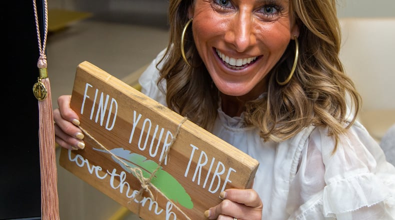 Joy Mitchell holds an encouraging sign she keeps at Office Creations in Norcross. She chose to go back to school to get her Bachelor's and MBA after running a multimillion-dollar company for over a decade. PHIL SKINNER FOR THE ATLANTA JOURNAL-CONSTITUTION.