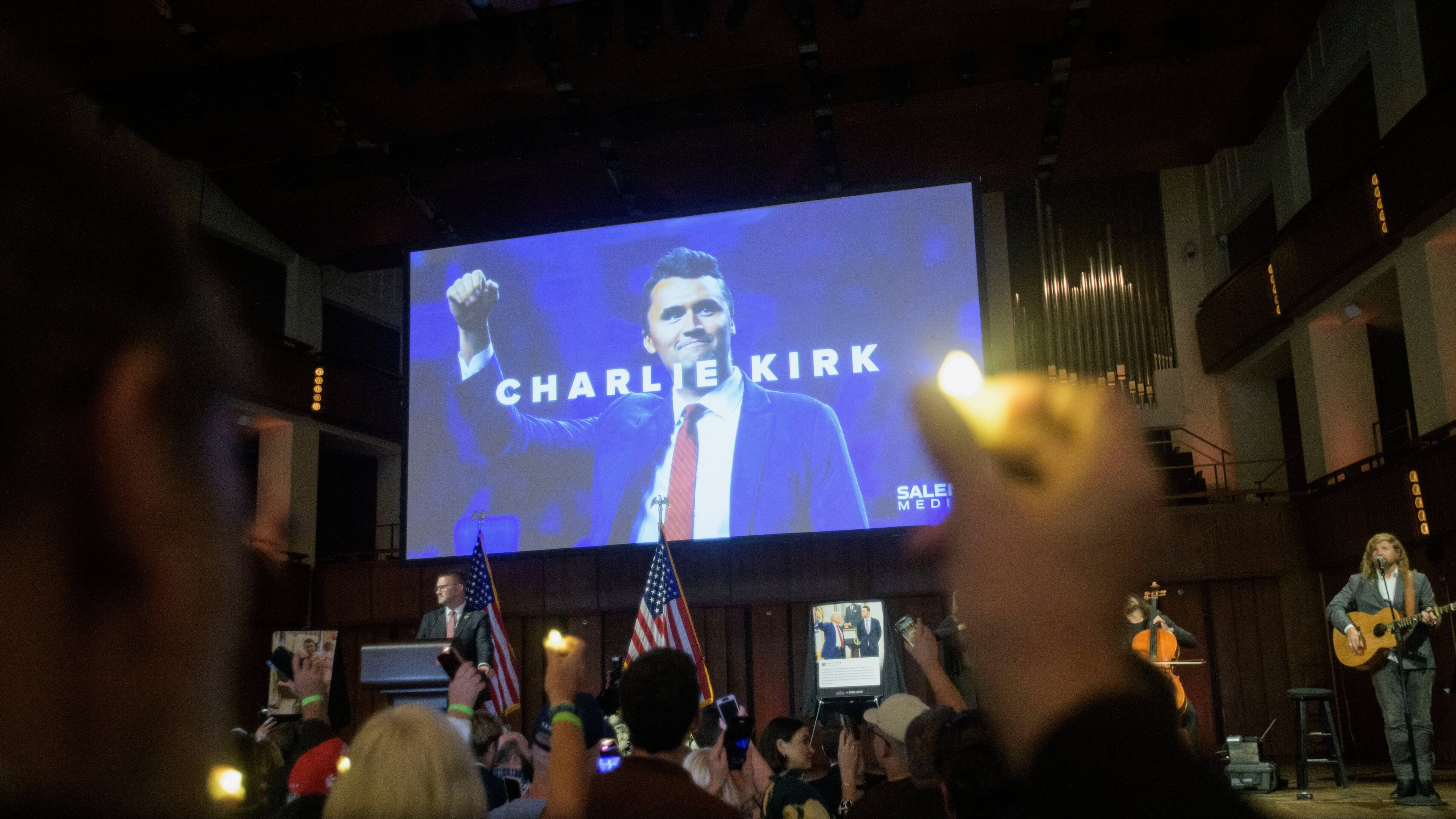 People hold candles and sing during a memorial and prayer vigil for Charlie Kirk at the John F. Kennedy Memorial Center for the Performing Arts, Sunday, Sept. 14, 2025, in Washington. (AP Photo/Rod Lamkey, Jr.)