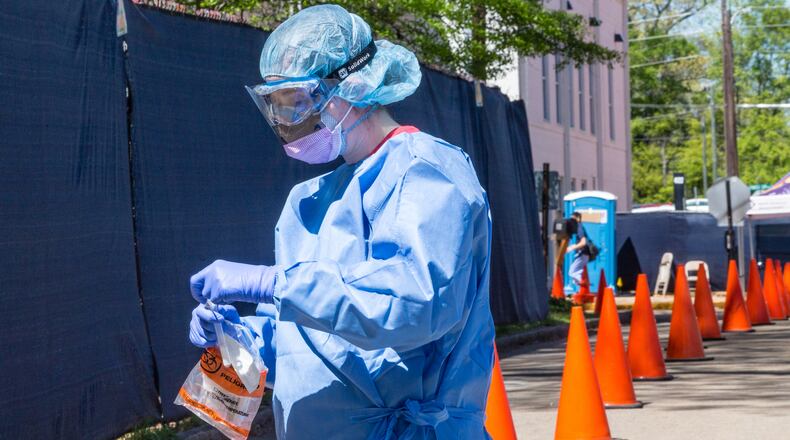 At the testing tent, Ansley Clements, a nurse at Ethne Health in the city of Clarkston, puts a sample taken from a walk-up individual into a medical bag to be taken for testing Friday, April 3, 2020. Ethne Health — in partnership with the city of Clarkston, community churches and food banks — provides free COVID-19 testing for people showing symptoms who live in the Clarkston area. Results take approximately 3 days. The coronavirus testing will continue on Saturday. (Jenni Girtman for the Atlanta Journal-Constitution)