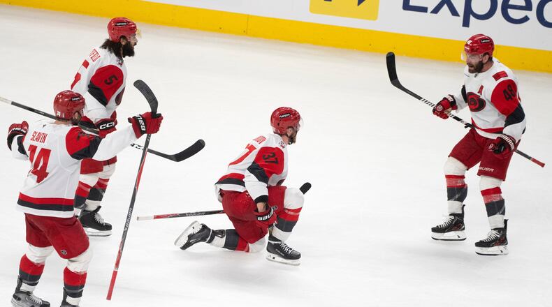 Carolina Hurricanes' Andrei Svechnikov (37) celebrates with teammates Jaccob Slavin (74), Jalen Chatfield (5) and Jordan Martinook (48) after a goal by teammate Sebastian Aho (not shown) during overtime of Game 3 of the Eastern Conference finals NHL hockey Stanley Cup playoff series against the Montreal Canadiens in Montreal, Monday, May 25, 2026. (Christinne Muschi/The Canadian Press via AP)