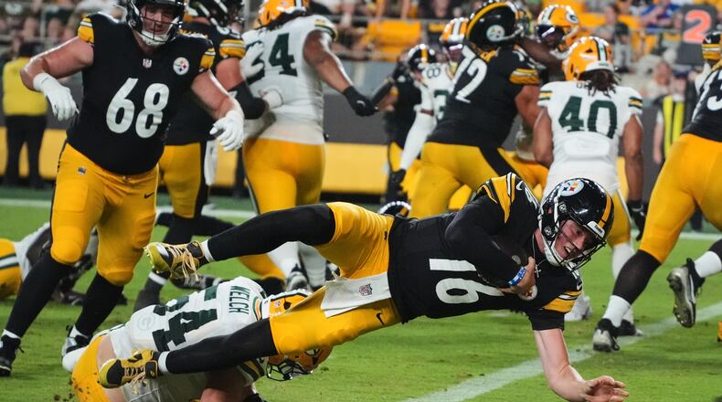 Pittsburgh Steelers quarterback Drew Allar (16) divers over Green Bay Packers linebacker Kristian Welch into the end zone for a touchdown in the second half of a preseason NFL football game in Pittsburgh, Thursday, Aug. 13, 2026. (AP Photo/Gene J. Puskar)