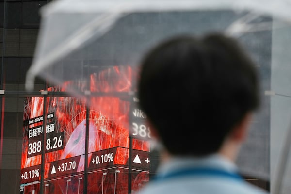 A person stands in front of an electronic stock board showing Japan's Nikkei index at a securities firm Wednesday, June 25, 2025, in Tokyo. (AP Photo/Eugene Hoshiko)
